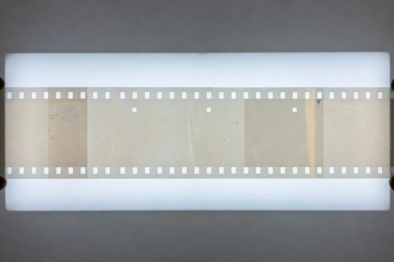 Transparent 35mm motion picture celluloid frames held up against backlit studio illumination